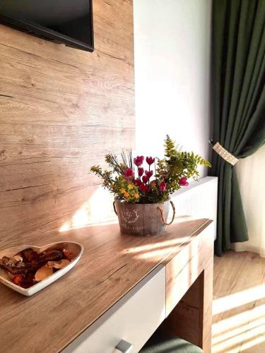 a table with a plate of food and flowers on it at Blumenhof Bucovina in Voronet