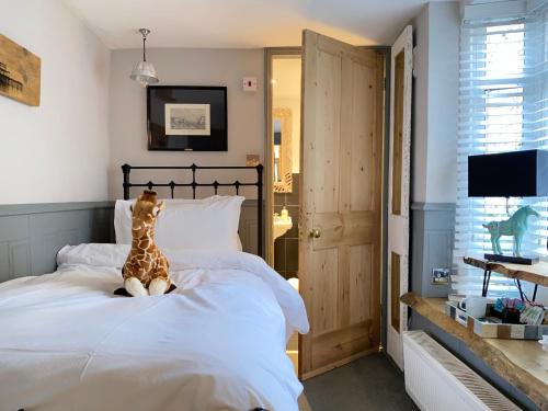 a giraffe sitting on a bed in a bedroom at 27 Brighton Guesthouse in Brighton & Hove