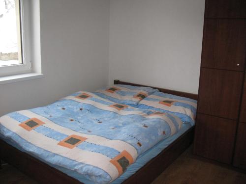 a bed with a blue comforter in a bedroom at Útulný dovolenkový dom in Liptovský Hrádok