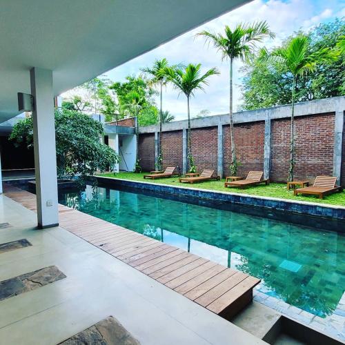 a swimming pool in a house with palm trees at Arachchi Heritage in Anuradhapura
