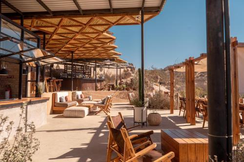 a patio with chairs and tables and a pavilion at Encuentro Guadalupe in Valle de Guadalupe