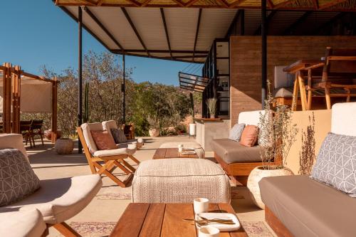 a patio with couches and a table and chairs at Encuentro Guadalupe in Valle de Guadalupe