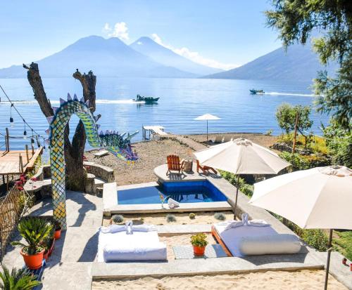 a resort with a pool and a view of the water at El Dragon Hotel in San Marcos La Laguna