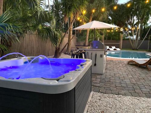 una grande vasca idromassaggio in un cortile con piscina di NEWLY RENOVATED POOL, HOT TUB, & EPIC BACKYARD a Fort Lauderdale