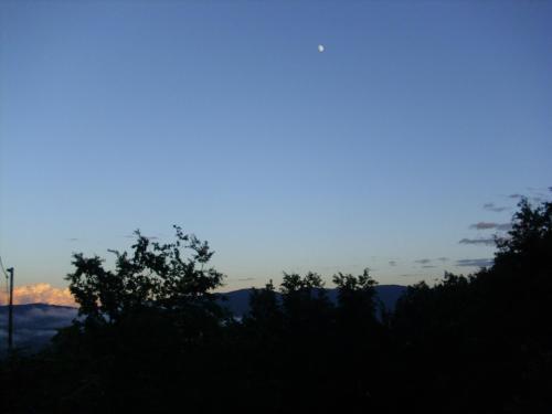 a sunset over the mountains with trees in the foreground at Tolasudolsa Rooms, Breakfast & Mountain Bike in Compiano