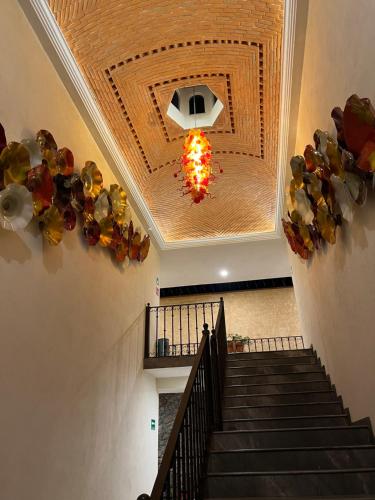 a staircase in a building with a chandelier at Mesón de las Delicias in Cuernavaca