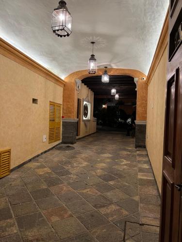 an empty hallway in a building with pendant lights at Mesón de las Delicias in Cuernavaca