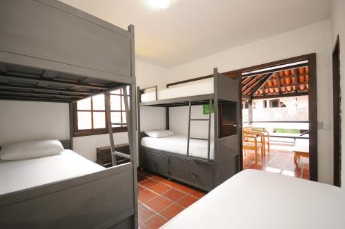 a bedroom with two bunk beds and a dining room at Che Lagarto Hostel Búzios in Búzios