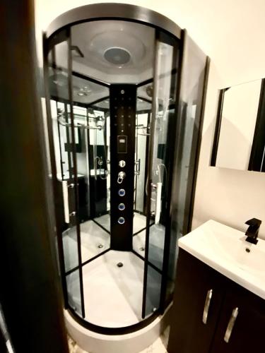 a glass shower in a bathroom with a sink at Duke and Duchess Apartments and Rooms - Private in Room Hot Tub Suites in London