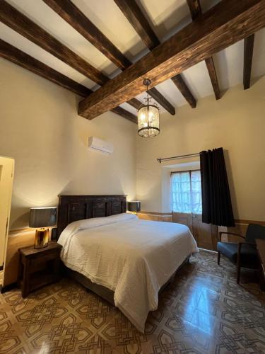 Un dormitorio con una cama grande y una lámpara de araña. en Mesón de las Delicias en Cuernavaca