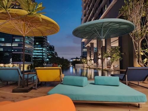 a patio with chairs and umbrellas in a city at Ai Smart Home , Bangsar South in Kuala Lumpur