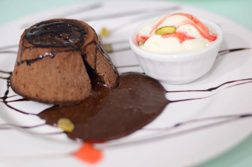 a plate with a chocolate dessert and a cup of sauce at Blaire Executive Suites in Manama