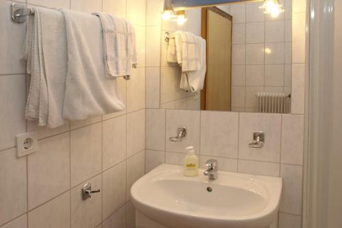 a bathroom with a sink and a mirror and towels at Ferienwohnung "beim Hirsch" Bregenzerwald in Langenegg