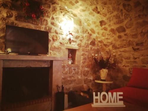 a living room with a fireplace and a television at Kristi's Homes - "Beautiful Dome" in Dimitsana in Dimitsana