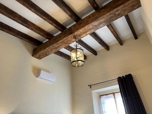 a ceiling with wooden beams and a light fixture at Mesón de las Delicias in Cuernavaca