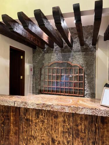 a bar in a room with a stone fireplace at Mesón de las Delicias in Cuernavaca