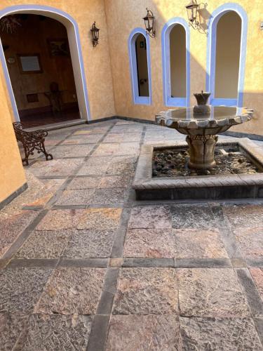 a stone courtyard with a fountain in front of a building at Mesón de las Delicias in Cuernavaca