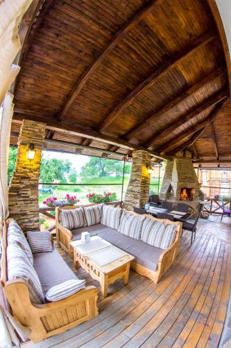 a living room with couches and tables on a wooden deck at Hata Hutsula in Mykulychyn