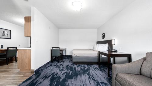 a hotel room with a bed and a desk and a couch at Atria Hotel and RV McGregor in McGregor