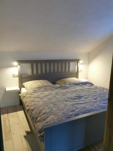 een slaapkamer met een blauw bed in een kamer bij Ferienwohnung "Am Wald" in Schmiedefeld am Rennsteig