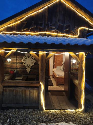 a log cabin with lights on it at night at Chatka Zapiecek in Krościenko