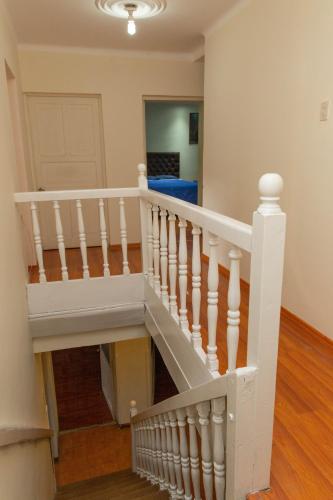 a staircase in a house with a white stair case at Cusco House Inn Hostel in Cusco