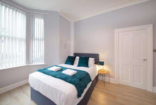 a bedroom with a large bed with two towels on it at Air Host and Stay - Arkles House sleeps 7 in Liverpool