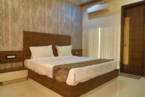 Un dormitorio con una cama grande con cabecero de madera. en HOTEL GOLDEN LEAF, en Mohali