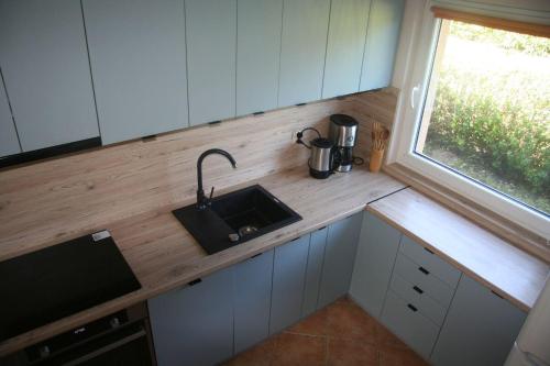 a small kitchen with a sink and a window at Domek w Poddąbiu blisko plaży i lasu in Poddąbie