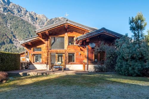 une cabane en rondins avec des montagnes en arrière-plan dans l'établissement Nice And Spacious Apt In Chamonix Mont Blanc, à Chamonix-Mont-Blanc