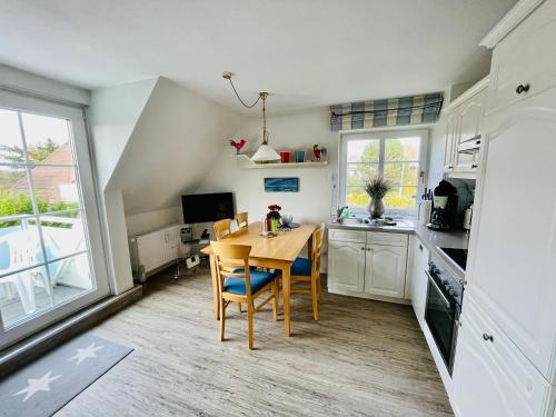 Una cocina con una mesa y sillas en una habitación. en Ruheoase am Dorfteich für 2-4 Personen, en Wenningstedt
