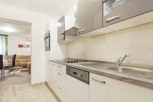una cocina con armarios blancos y fregadero en Apartment Jasmin, en Split