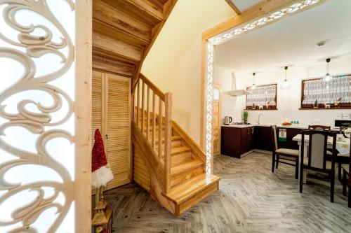 a room with a staircase and a dining room at Komfortowe domki na wynajem - Holiday Tatry in Poronin