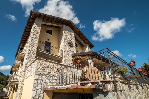 a building with a balcony and a blue sky at Albergo Ad Astra in Pescasseroli