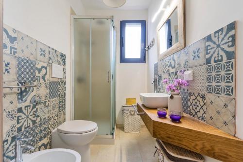 a bathroom with a toilet and two sinks and a shower at DIMORA FEO in Gallipoli
