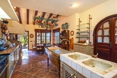 eine große Küche mit 2 Waschbecken und einem Tisch in der Unterkunft Casa Flores con Piscina interior climatizada in Alcaucín
