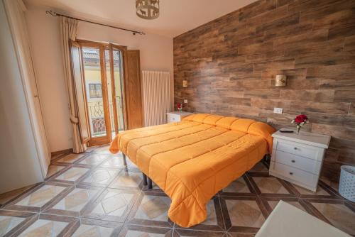 a bedroom with a large bed with an orange blanket at Albergo Ad Astra in Pescasseroli