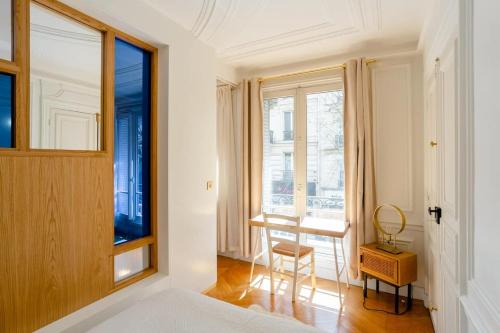 une chambre avec un lit, un bureau et une fenêtre dans l'établissement Bel appartement dans le 9ème, à Paris