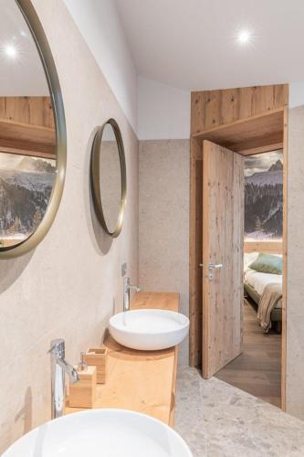 a bathroom with a sink and a mirror and a bed at B&b Il Sogno in Campolongo