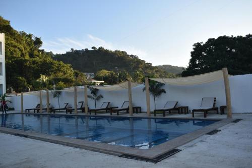a swimming pool with chairs and aermottermottermott at MALAKI in Los Ayala