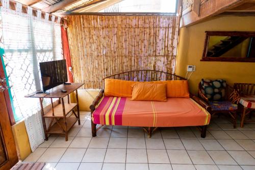 a bedroom with a bed in a room with a window at Casa Mexica Bungalows in Zihuatanejo