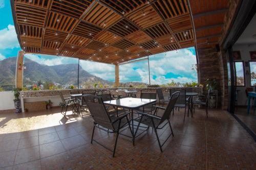 een restaurant met tafels en stoelen en uitzicht op de bergen bij Hotel Maggic Home Panorámica in Guanajuato