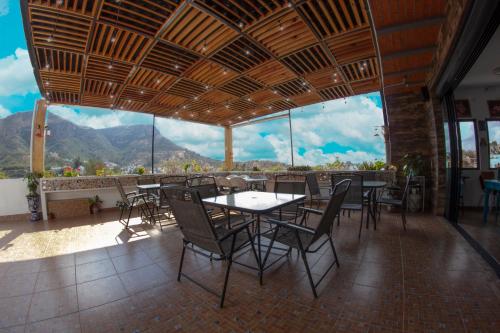 a restaurant with tables and chairs and a view of mountains at Hotel Spa Maggic Home Panorámica in Guanajuato