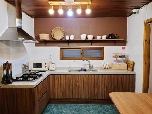 a kitchen with a sink and a stove top oven at Batwo Stay - For foreigners only in Seoul
