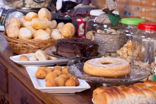 eine Theke mit verschiedenen Arten von Gebäck und anderen Lebensmitteln in der Unterkunft Pouso da Josi - Tiradentes in Tiradentes