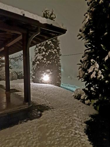 a snow covered sidewalk with a light in the background at B&B Margot in Albavilla