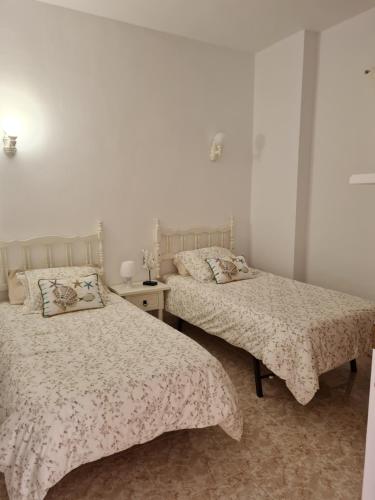 Dos camas en una habitación con paredes blancas. en Apartamento La Barranquera, en La Laguna