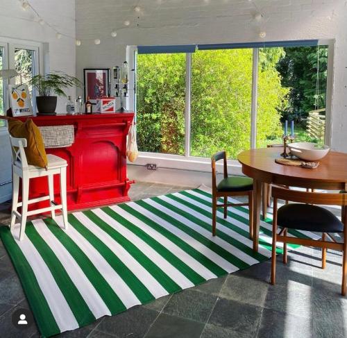 a living room with a table and a red fireplace at Little Woodbank in Portadown