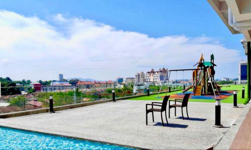- une aire de jeux avec toboggan et chaises à côté de la piscine dans l'établissement Bunga Homestay Hill View, à Kuala Terengganu