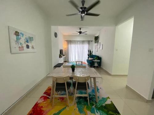 a living room with a table and chairs on a rug at Bunga Homestay Icon Residence KUALA TERENGGANU in Kuala Terengganu